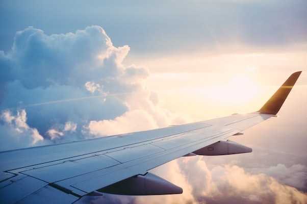 Image of the wing of a plane, taken from the perspective of someone in the plane looking out of the window..